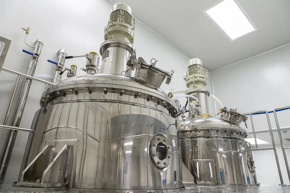 Sala limpa farmacêutica em indústria com duas máquinas redondas de aço inoxidável.