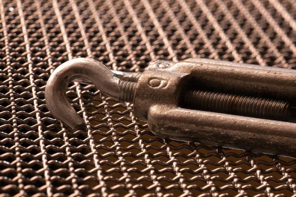 Imagem detalhada de um esticador com um gancho de metal de aço carbono oxidado.